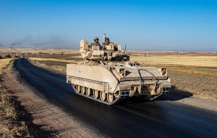 US soldiers in a Bradley Fighting Vehicle (BFV) patrol the countryside of al-Malikiya town