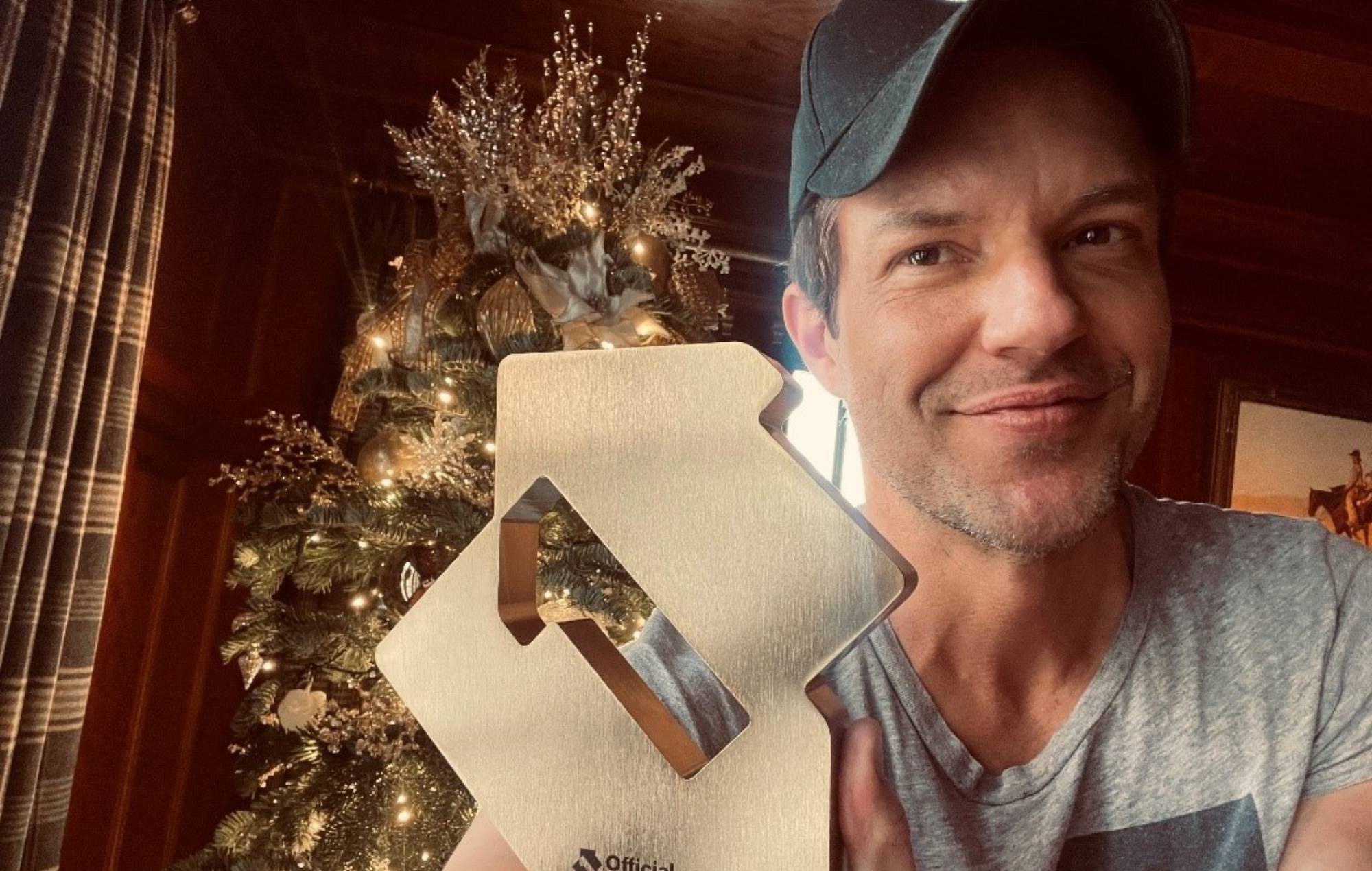 The Killers’ Brandon Flowers poses with his Official Number 1 Album Award celebrating the group’s Official Number 1 LP Rebel Diamonds (credit: Official Charts)